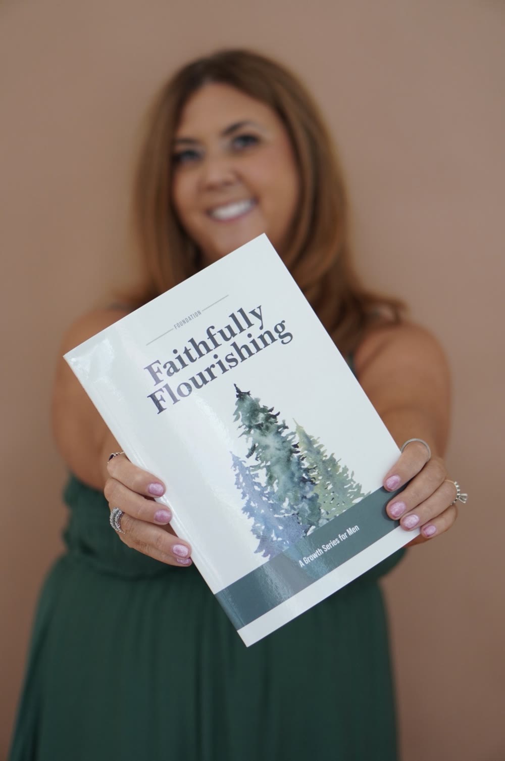 Ginger Steg holding the Faithfully Flourishing men's devotional